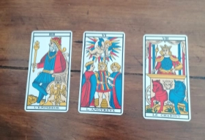 Tirage de Tarot en trois cartes posé sur une table : passé, présent, futur.